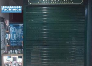 Fachada comercial con cierre metálico FC115 microperforado